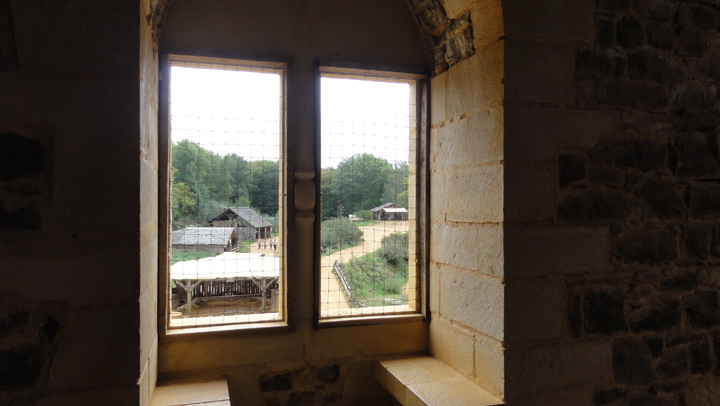 une fenêtre à coussièges et la vue de la grande salle dans le logis seigneurial